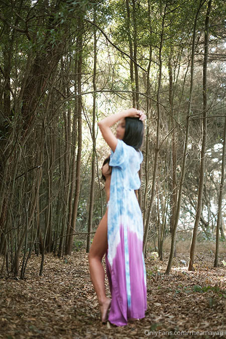Vanessa Rallonza, a stunning 34-year-old Filipino-American woman with dark brown hair, poses seductively in a long, flowing dress, surrounded by the lush greenery of the forest. Her curvaceous figure is on full display as she gazes into the camera with a sultry smile, her nude skin glowing in the soft light of the woods. The dress hugs her body in all the right places, accentuating her femininity and leaving little to the imagination. Vanessa exudes a confident, seductive energy, drawing the viewer in with her unwavering gaze.