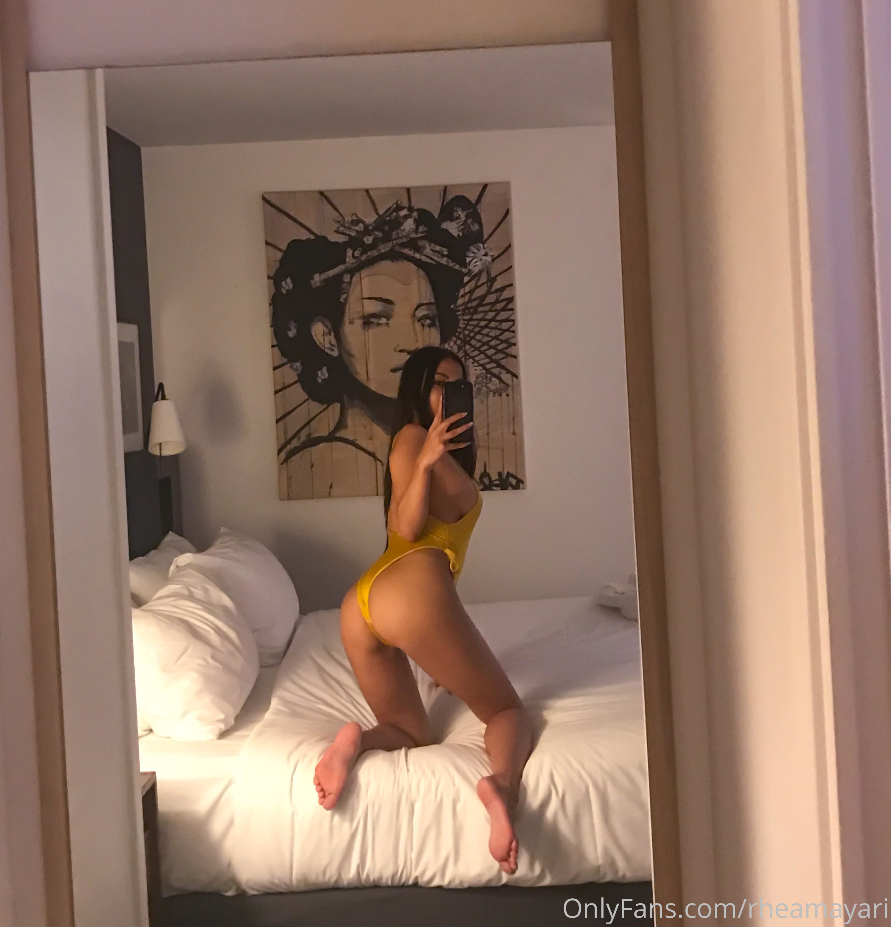 Vanessa Rallonza, a petite 34-year-old Filipino-American woman with dark brown hair, strikes a sultry pose in a yellow bikini, capturing her radiant beauty in a selfie that will leave you breathless.