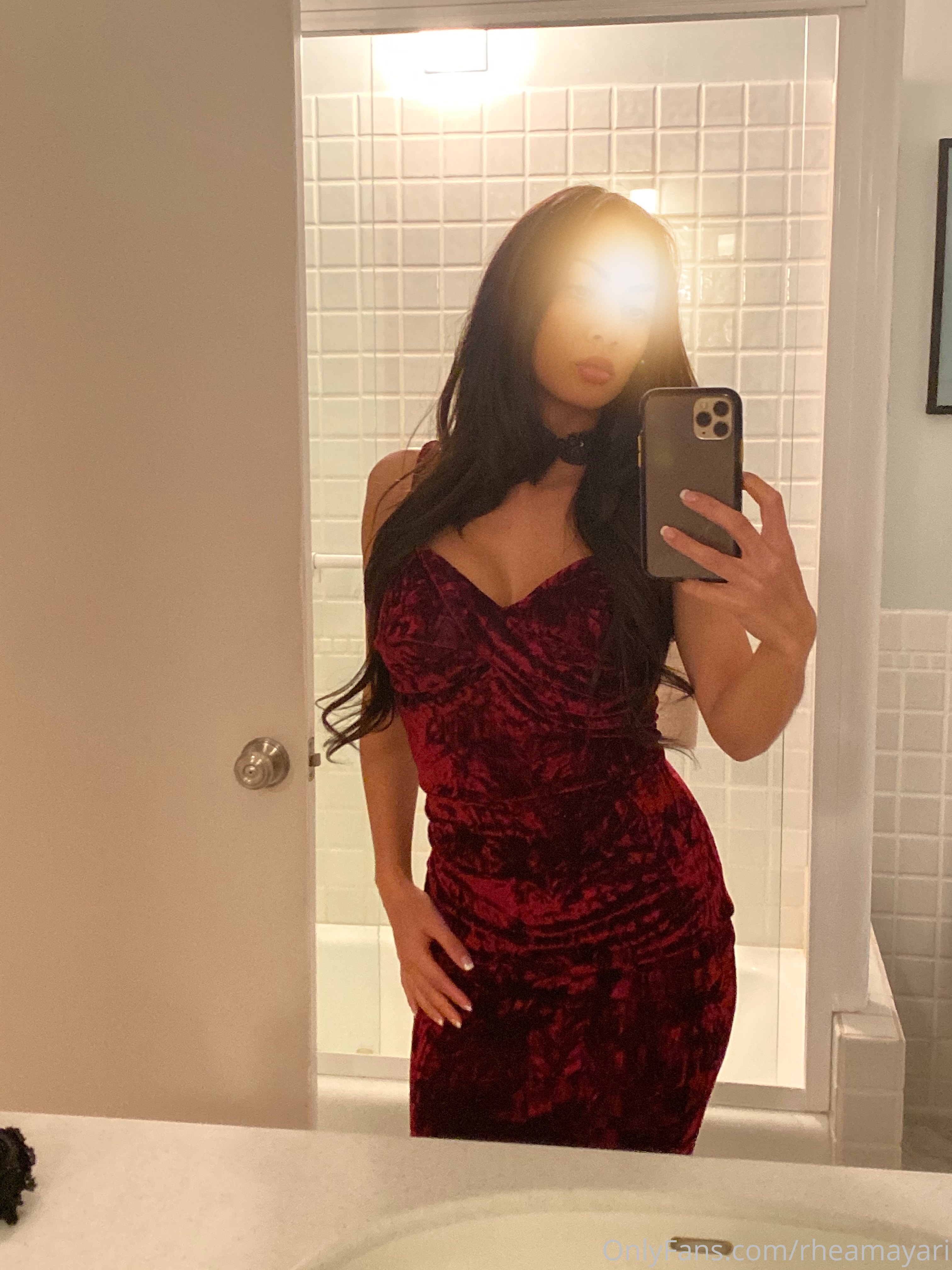 Vanessa Rallonza, a petite 34-year-old Filipino-American woman with dark brown hair, strikes a seductive pose in the bathroom mirror, her nude form glimmering in the dim light.